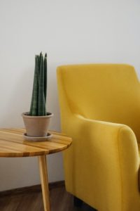 Weiße Wand, Retro-Tisch mit Grünpflanze und gelber Sessel
